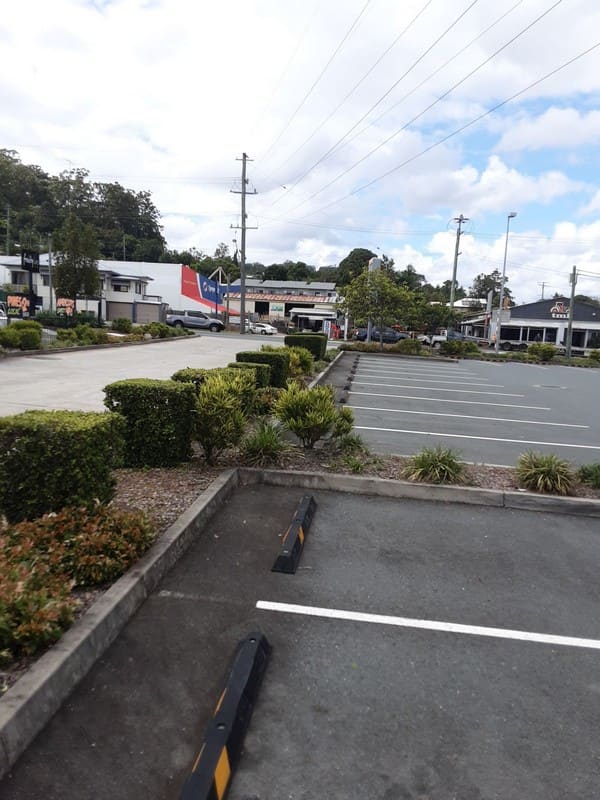 Commercial carpark with maintained hedges and landscaping