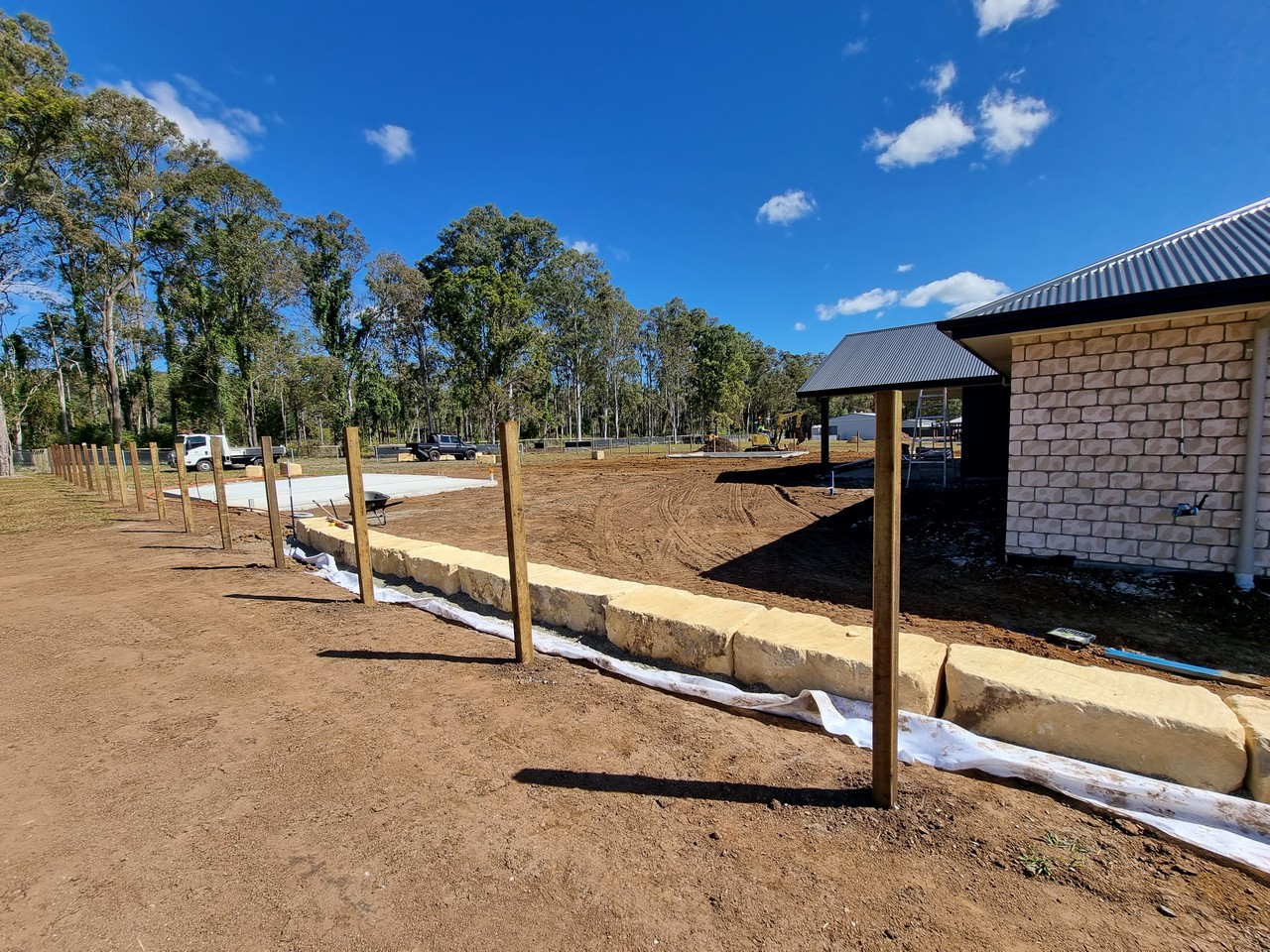 Sandstone retaining wall with timber fence posts