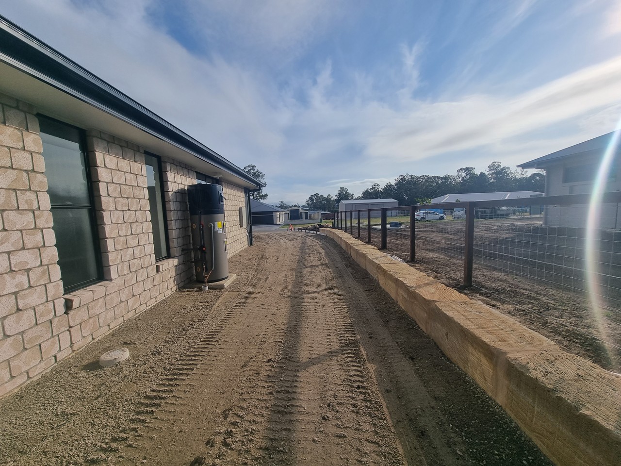 Completed sandstone boundary wall with fencing