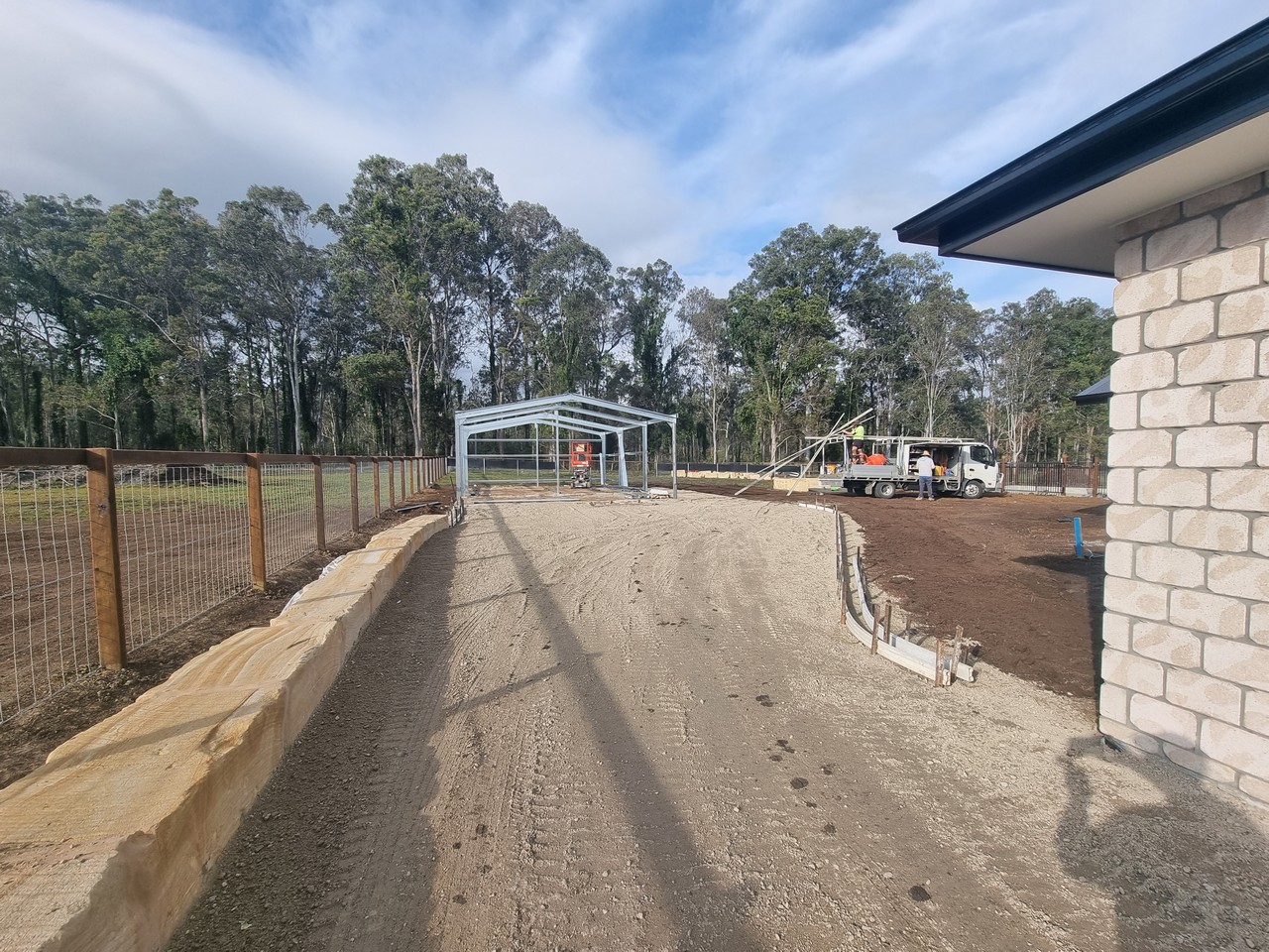 Driveway grading with retaining wall and shed frame