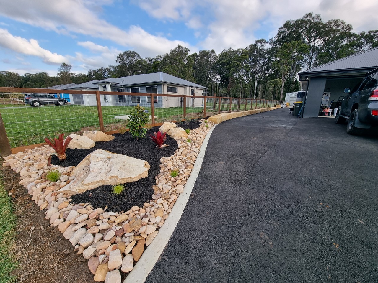 Finished landscaping with rock garden and driveway