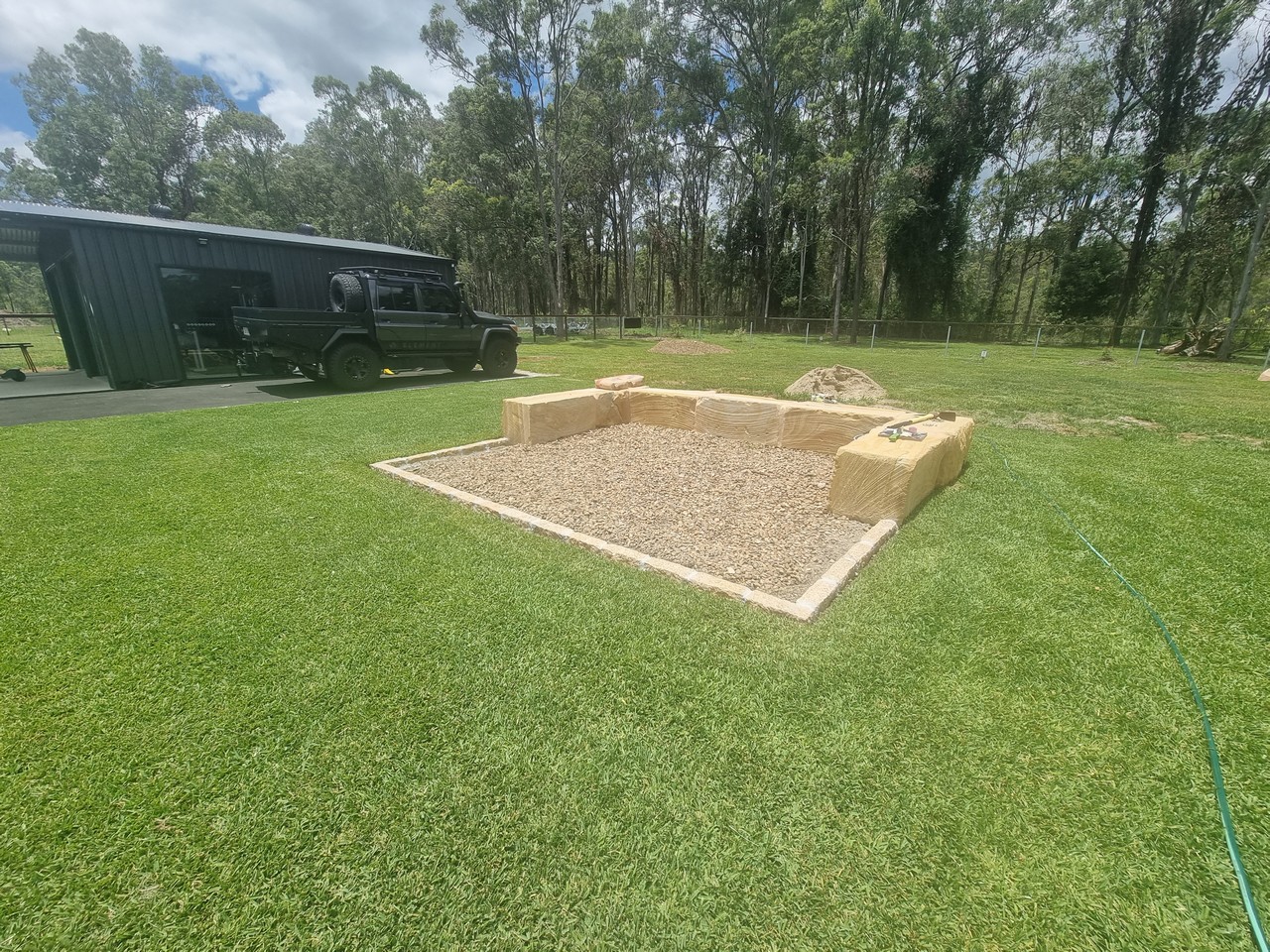 Completed sandstone firepit area with turf